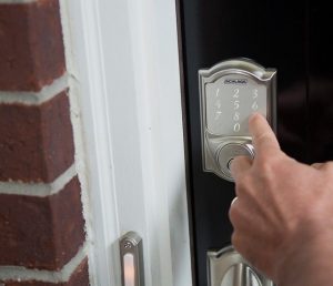 A Schlage Smart Deabolt being unlocked outside a home.