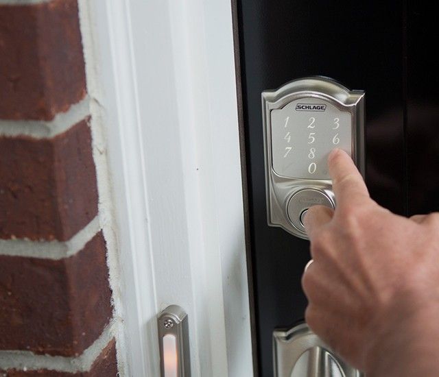 A Schlage Smart Deabolt being unlocked outside a home.