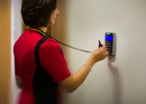 An employee using an AMAG access card to unlock a door