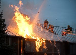 Firefighters fighting a fire at a burning home.