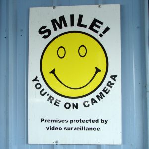 A sign reading "SMILE! YOU'RE ON CAMERA"