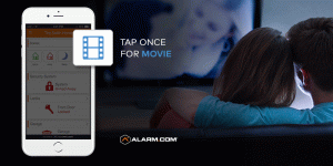 Alarm.com app showing the "movie" scene button with a couple on a couch in the background.