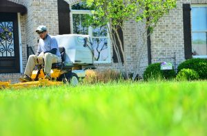 A lawn care worker on a riding mower.
