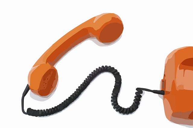An orange phone with a cord