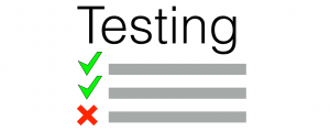 A paper reading "Testing" with check marks and an "x."