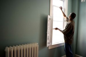 A man opening a window in a home