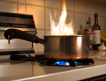A fire in a pan on a stove