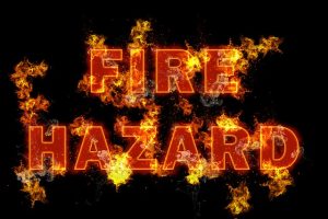 A sign reading "Fire Hazard" with letters on fire